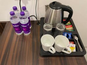 a tray with water bottles and cups on a table at Hotel Mahavir in Ankleshwar