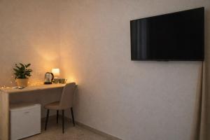 a room with a table and a television on the wall at Masseria Coccolo in Carovigno