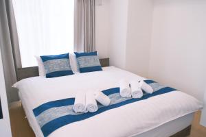 a bedroom with a bed with towels on it at The Peak Tsutenkaku Apartment Hotel in Osaka