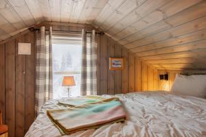 a bed in a room with a wooden ceiling at Flott utsikt Peis Elbillader in Aurdal