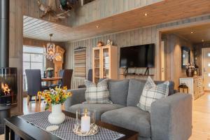 a living room with a couch and a table at Flott utsikt Peis Elbillader in Aurdal