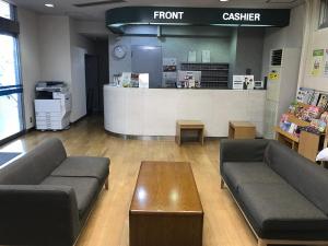 a store with couches and a coffee table and a counter at New Central Hotel Katsuta in Hitachinaka