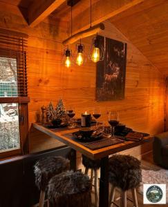 a dining room with a table with glasses of wine at Chalet Lodge - O'Bord de l'Eau in Gérardmer