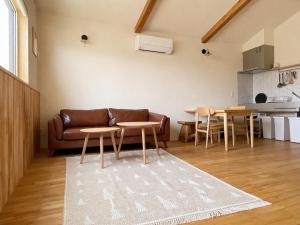 a living room with a leather couch and a table at mizuki natural villa Garden in Higashikawa