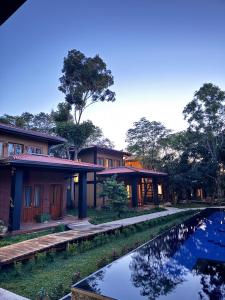 a row of houses with a pond in front of them at Aria Resort in Sigiriya