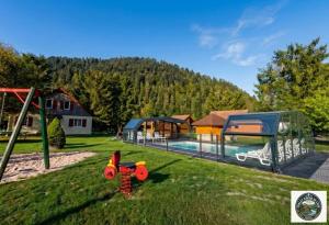 a childrens playground with a pool and a house at Chalet Lodge - O'Bord de l'Eau in Gérardmer +2 photos