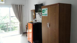 a room with a wooden cabinet with a sign on it at Aple Homestay in Amphawa