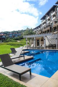 a swimming pool with lounge chairs and a building at 204 Zimbali Suites in Ballito