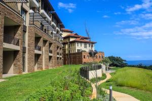 an exterior view of a building with a pathway at 204 Zimbali Suites in Ballito