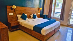 a bedroom with a large wooden bed with blue pillows at Haven On Hill - Rishikesh in Rishīkesh +51 photos