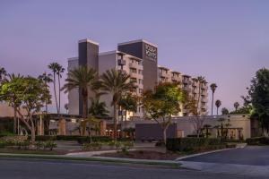 a building with palm trees in front of a street at Four Points by Sheraton Los Angeles Westside in Los Angeles