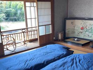 a bedroom with a bed and a balcony at 名場越庵 -Nabakoshian- in Karatsu