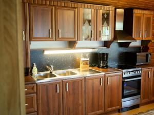 a kitchen with wooden cabinets and a sink and a stove at Juhantupa in Keuruu