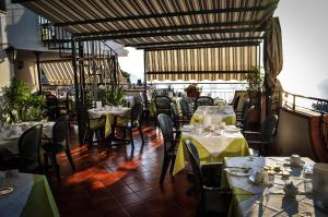 a dining room with tables and chairs with white tablecloths at Hotel Condor in Taormina