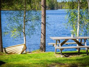 a picnic table and a boat next to a lake at Juhantupa in Keuruu +4 photos