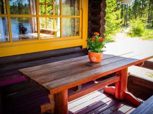 a potted plant sitting on a wooden bench on a porch at Juhantupa in Keuruu