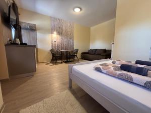 a bedroom with a bed and a living room at NAPSUGAR VENDÉGHÁZ in Bogács
