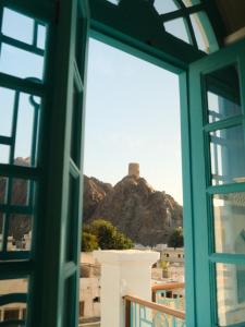 a window with a view of a mountain at Al Bait Al Sharqi in Muscat +36 photos