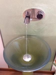 a stream of water pouring into a bathroom sink at Villa Susina in Toscolano Maderno