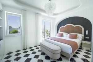 a bedroom with a large bed and a chandelier at Lussi Capri in Anacapri