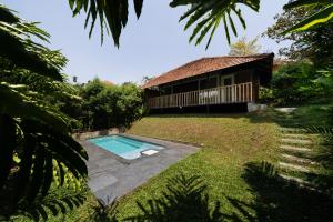 a house with a swimming pool in the yard at Aalterra Resort by The Almanac in Wayanad