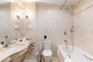 een badkamer met een toilet, een bad en een wastafel bij Club Hotel Corona in Kazan