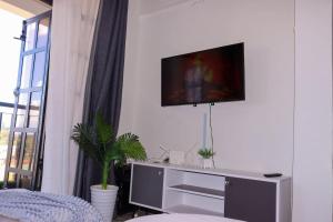 a living room with a tv on a white wall at Gessy Homes in Eldoret