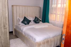 a bedroom with a white bed with pillows at Gessy Homes in Eldoret