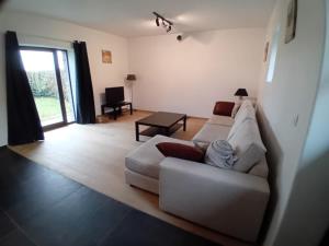a living room with a white couch and a table at Ferme de la Naverie wi - holiday home for 2 persons in Celles