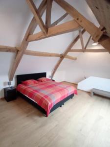 a bedroom with a red bed in a attic at Ferme de la Naverie wi - holiday home for 2 persons in Celles
