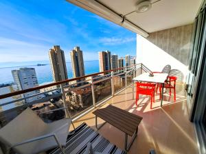 a balcony with a table and chairs and a view of the city at Coblanca 41-spectacular views-gym-heated pool-sauna-jacuzzi-wifi-3 minutes walk from the sear in Benidorm