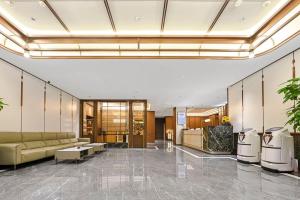 a lobby with a couch and tables in a building at 黑河易达酒店 in Heihe