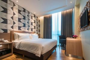 Un pat sau paturi într-o cameră la Luminor Hotel Pecenongan Jakarta By WH