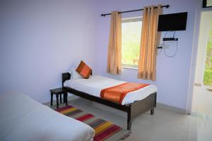 a bedroom with two beds and a window at Amar Bagh Ranthambore in Khilchipur