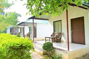 a porch of a house with two chairs and a table at Amar Bagh Ranthambore in Khilchipur