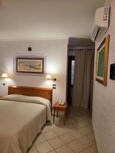a hotel room with two beds and a table at Hotel Ristorante Rinelli in Margherita di Savoia