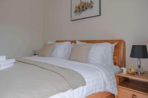 a bedroom with a bed with white sheets and pillows at Uncle Toy in Ban Riang