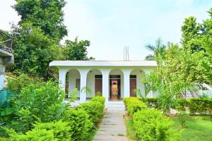 a white house with a pathway leading to it at Amar Bagh Ranthambore in Khilchipur