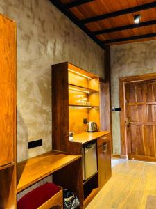 a small kitchen with wooden counters and a door at Aria Resort in Sigiriya