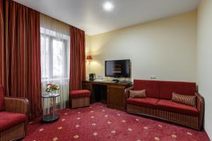 カザンにあるクラブ ホテル コロナの椅子2脚とテレビが備わるホテルルームです。