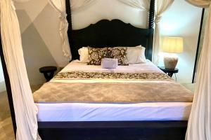 a bedroom with a large bed with a black headboard at The Kubu Sidemen in Silebeng