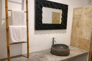 a bathroom with a large stone bowl on a counter at The Kubu Sidemen in Silebeng