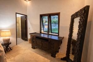a room with a mirror and a wooden dresser at The Kubu Sidemen in Silebeng +2 photos