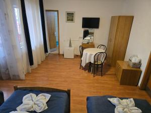 a living room with two beds and a table at Pensiune Supca in Râmnicu Vâlcea +52 photos