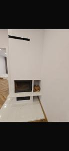 ein weißer Schrank mit einem Kamin in einem Zimmer in der Unterkunft Kulesza in Dubeninki