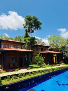 a house with a swimming pool in front of it at Aria Resort in Sigiriya