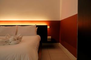 a bedroom with a bed with white pillows and red walls at The 501 by Shmoo in Sliema