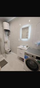 ein Badezimmer mit Toilette, Waschbecken und Waschmaschine in der Unterkunft Kulesza in Dubeninki