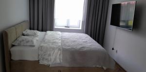 ein Schlafzimmer mit einem Bett mit Kissen und einem Fenster in der Unterkunft Kulesza in Dubeninki