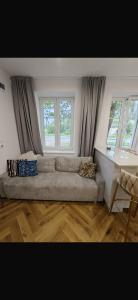 ein Wohnzimmer mit einer Couch und zwei Fenstern in der Unterkunft Kulesza in Dubeninki